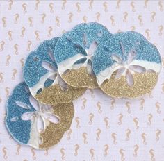 four pieces of blue and gold glittered paper