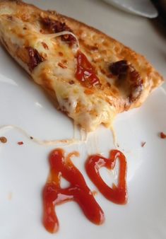 a slice of pizza on a plate with ketchup drizzled around it