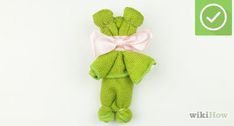 a green stuffed animal with a pink bow