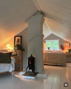 an attic bedroom with white walls and wood floors