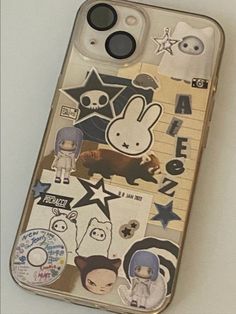 an iphone case with many stickers on the front and back sides, including cartoon characters