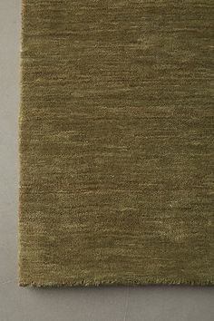 an area rug that looks like it is made out of green wool and has been placed on the floor