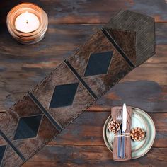 the table is set with plates, silverware and pinecone placemats