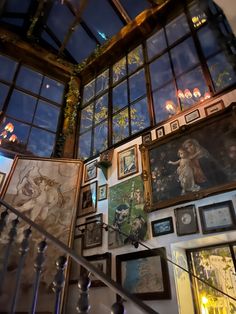 a staircase with many framed pictures on the wall and below it is a skylight