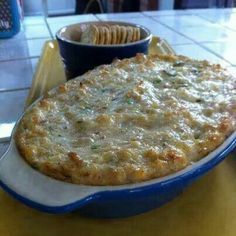 a blue and white plate topped with food next to a bowl filled with crackers