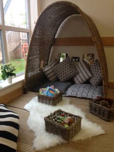 a living room filled with lots of furniture and pillows on top of a carpeted floor