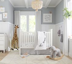 a baby's room with giraffes, crib and other furniture