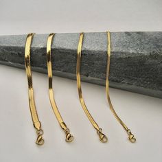 Our Snake Chain Bracelet is your perfect go-to accessory for everyday bracelet stacking support. With its flat lay design, it'll instantly add a touch of edge to your look! Materials: Gold stainless steel (No Tarnish) Flat snake chain Lobster claw clasp Measurements: 2mm width, 6" long with 2" extender 3mm width, 6" long with 2" extender 4mm width, 6" long with 2" extender 5mm width, 7" long with 2" extender Gold Snake Chain Bracelet, Gold Anklet Designs, Flat Snake Chain, Mandala Digital, Real Gold Chains, Gold Snake Chain, Diamond Pendants Designs, Modern Gold Jewelry, Art Jewelry Design