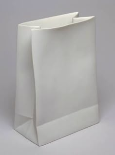 a white paper bag sitting on top of a gray surface with the bottom half open