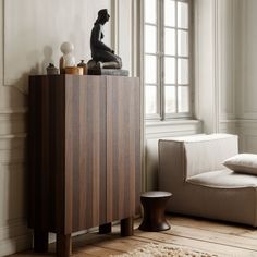 a living room with a couch, chair and sideboard in front of a window