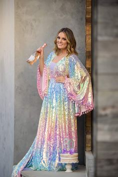 Our beautiful “Rainbow Disco" gown was designed after our own designers love for bohemian vibes and all things lace. This gorgeous gown is made with a beautiful pastel sequin fabric. We have added an elastic waist to the dress which adds extra sizing capabilities. Flair sleeves adorned with pink tassels. We have also added tassels to her back of bodice. This dress can easily size up and down. Dress comes with a detachable slip-Slip is exact measurements provided-so there is no give/stretch. You Up And Down Dress, 70s Fashion Women, Flair Sleeves, Holographic Dress, Thrift Store Clothes, Fairytale Fashion, Bohemian Vibes, Rainbow Dress, Down Dress