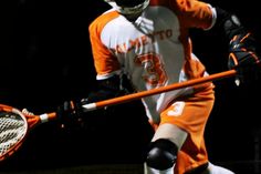 a lacrosse player wearing an orange and white uniform