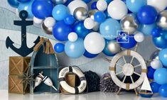 blue, white and silver balloons are on display in front of a boat steering wheel