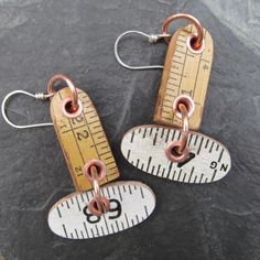 two pairs of earrings with measuring tape on them