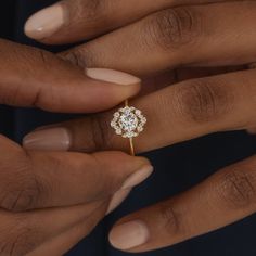 a close up of a person's hand holding a diamond ring