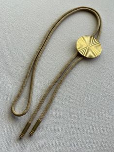 Luxury Artisan Sterling Silver Bolo Tie, Modern Bolo Tie, Gold Bolo Tie, Adjustable Metal Lariat Necklace For Formal Occasions, Adjustable Gold-tone Lariat Necklace For Formal Occasions, Adjustable Brass Necklace With Cord, Brass Necklace With Adjustable Cord, Gold Lariat Jewelry With Sliding Knot, Vintage Adjustable Bolo Ties