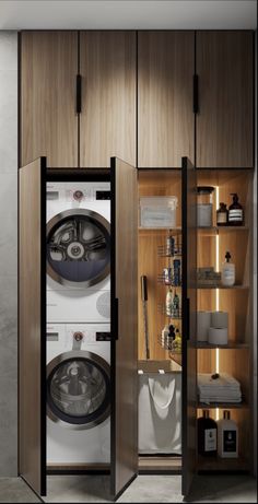 a washer and dryer sitting inside of a wooden cabinet next to each other