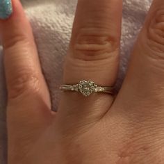 a close up of a person's hand with a diamond ring on their finger