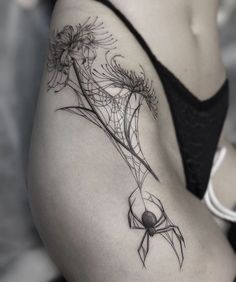 a black and white photo of a woman's thigh with flowers on her side