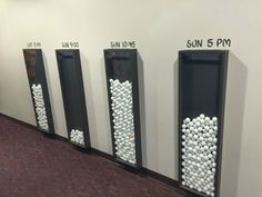 three urinals with balls in them are lined up on the wall next to each other