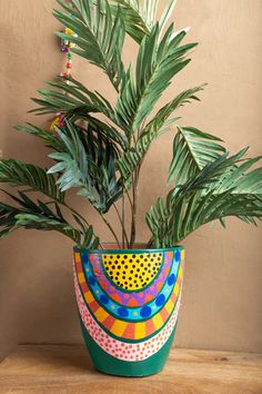 a potted plant sitting on top of a wooden table next to a brown wall