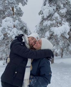 two women hugging each other in the snow