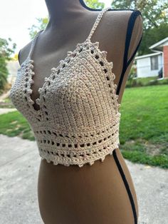 a mannequin wearing a crochet bralet in front of a house