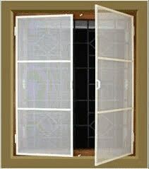 an open closet door with white mesh on the bottom and black linings, in front of a brown wall