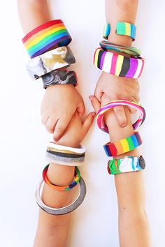 two children holding hands with colorful bracelets on their wrists and one child's hand in the other