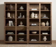 a wooden bookcase filled with lots of vases