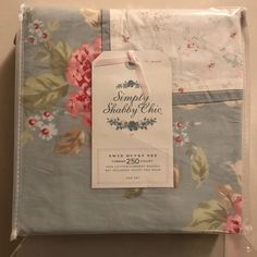 two sheets with pink flowers on them and a tag hanging from the top of one