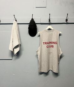 there is a training club shirt hanging on the wall next to two towels and a hat