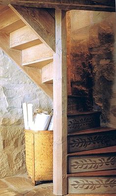 a basket sitting on top of a set of stairs next to a stone wall and wooden steps