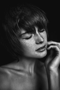 a black and white photo of a woman with freckled hair talking on a cell phone