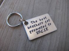 a metal keychain with the words, the best brothers get promed to uncle lee