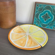 an orange slice is cut in half on a plate next to a jar with a brown substance