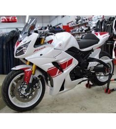 a white and red motorcycle parked in a garage