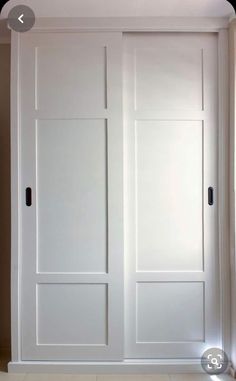 an empty room with two white doors and no one is in it or someone has just opened the door