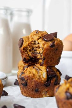 chocolate chip muffins stacked on top of each other with milk in the background