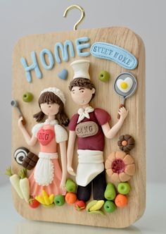 a wooden plaque with two people standing next to each other and holding utensils