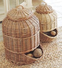 two wicker baskets sitting on top of a rug next to each other with balls in them