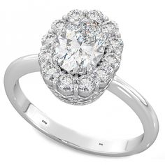 a white gold ring with an oval cut diamond surrounded by small round diamonds