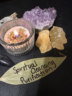 a candle and some crystals on a table with a sign that says, srindu ghansing purifaton