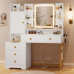 a white desk with a lighted mirror on top of it next to a wall mounted shelf