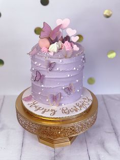 a purple birthday cake with butterflies on top