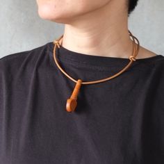 1点もの　在庫即納品 CHOKER “UKE / ウーク" アフリカのお土産のような1960年代のウクレレのウッドペグと、本革のコードで、とてもソリッドなチョーカーを作りました。コードは長さが調節できるので、お洋服に合わせてトップの位置を変えられます。 ウクレレのウッドペグは、同じモノはありません。 コード : 約34cm〜66cm ウッドペグの高さ：A 4.8cm / B 5.8cm / C 5.8cm / D 5.3cm / E 4.9cm 素材：コード=革、ペグ=木 重さ：約7g 6,000円＋TAX ＊在庫商品は、約4〜5日以内に発送します。 ＊サイズは多少誤差があります。＊女性モデルMINMIN身長153cm ＊子供モデル Jean Apron, The Vivienne, Wooden Pegs, Eco Bag, Ukulele, Leather Cord, A 4, Choker, Genuine Leather