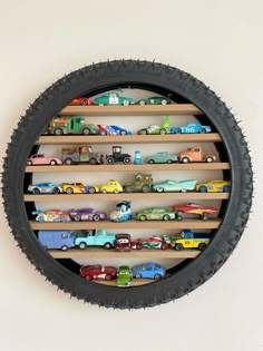 a wall mounted toy car display in a circle with wooden shelves and black tire rim