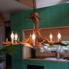 a chandelier made out of antler branches with candles lit in the middle