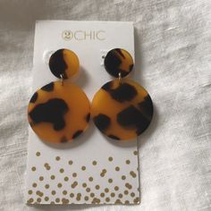 a pair of tortoise shell earrings sitting on top of a card