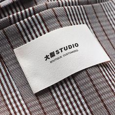 a label on a dress shirt that is not made in china or japan, with the name tstudio printed on it